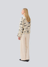 Shirt with V-neck and loose sleeves. MistMD print top has a loose fit and a button closure with fabric covered buttons.