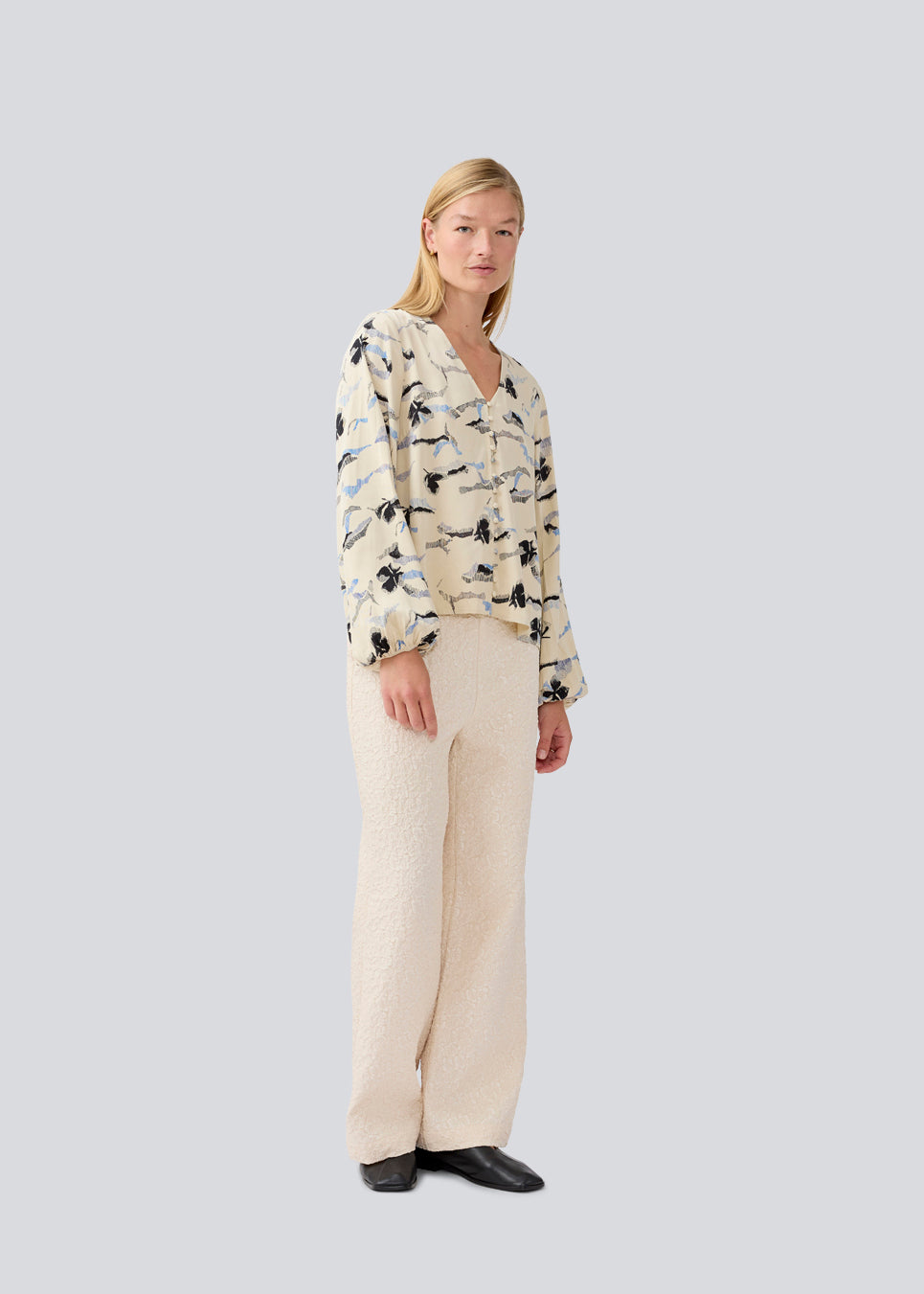 Shirt with V-neck and loose sleeves. MistMD print top has a loose fit and a button closure with fabric covered buttons.