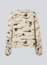 Shirt with V-neck and loose sleeves. MistMD print top has a loose fit and a button closure with fabric covered buttons.