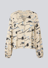 Shirt with V-neck and loose sleeves. MistMD print top has a loose fit and a button closure with fabric covered buttons.