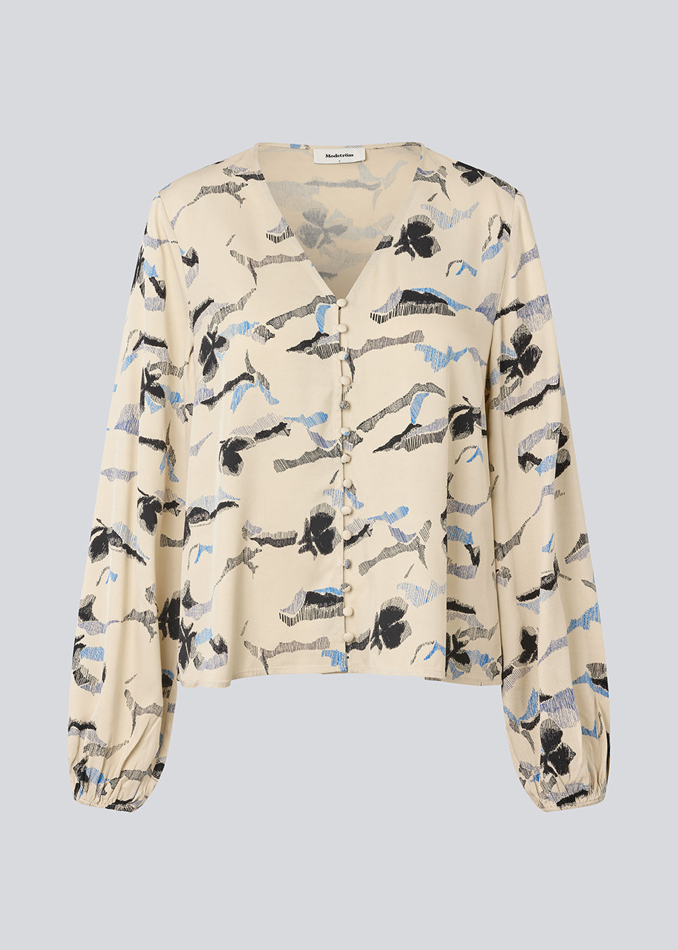 Shirt with V-neck and loose sleeves. MistMD print top has a loose fit and a button closure with fabric covered buttons.
