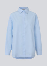 Blue classic shirt with an oversize fit. MyraMD shirt has a hidden buttonclosure in front and slits in the sides. The model is 177 cm and wears a size S/36.
