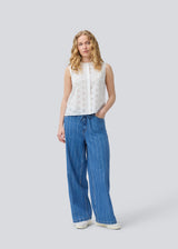 Sleeveless white top in broderie anglaise. NanetteMD top has a high neck and a button closure in front.