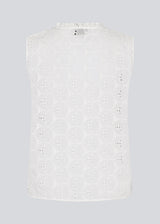 Sleeveless white top in broderie anglaise. NanetteMD top has a high neck and a button closure in front.