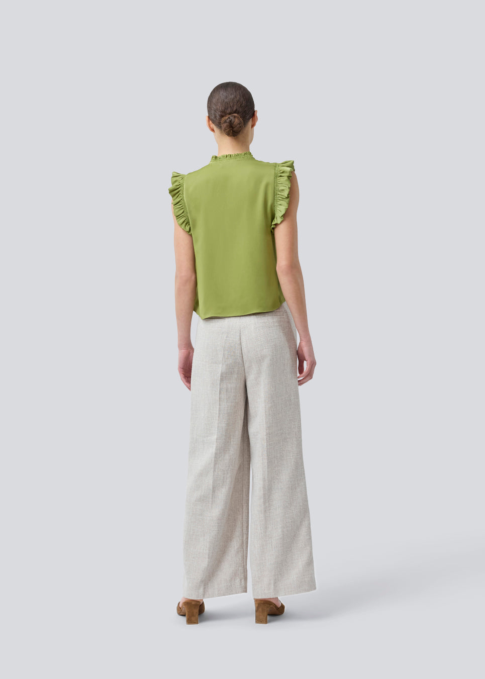 Sleeveless top in green with frill details and a loose fit. NarcissaMD top has frills at the sleeves and neckline, and an opening in front with a tieband closure.