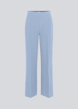 Classic pants in light blue with pressfolds and straight legs. Nelli pants are closed by an hidden zipper at the side with an elastic waistband for a more comfortable fit. The model is 175 cm and wears a size S/36