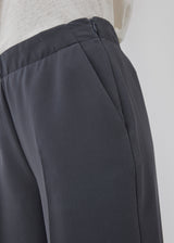 Classic pants in grey with pressfolds and straight legs. Nelli pants are closed by a hidden zipper at the side with an elastic waistband for a more comfortable fit. The model is 173 cm and wears a size S/36