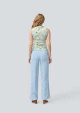 fitted top in an elastic material. NettieMD print top is sleeveless, has a high neckline, and has gatherings in the side