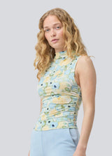 fitted top in an elastic material. NettieMD print top is sleeveless, has a high neckline, and has gatherings in the side