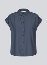 Sleeveless shirt in blue with button closure in EcoVero viscose. NickiMD SS shirt has a loose fit and gathers at the shoulder.