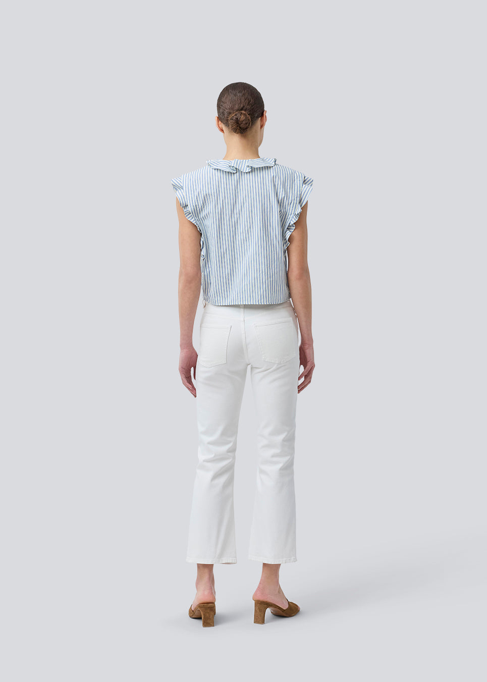 Sleeveless top with frill details and a button closure in front with stripes. NikkoMD top is slightly cropped and has a v-neck.
