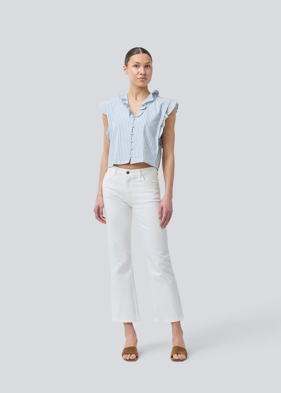 Sleeveless top with frill details and a button closure in front with stripes. NikkoMD top is slightly cropped and has a v-neck.