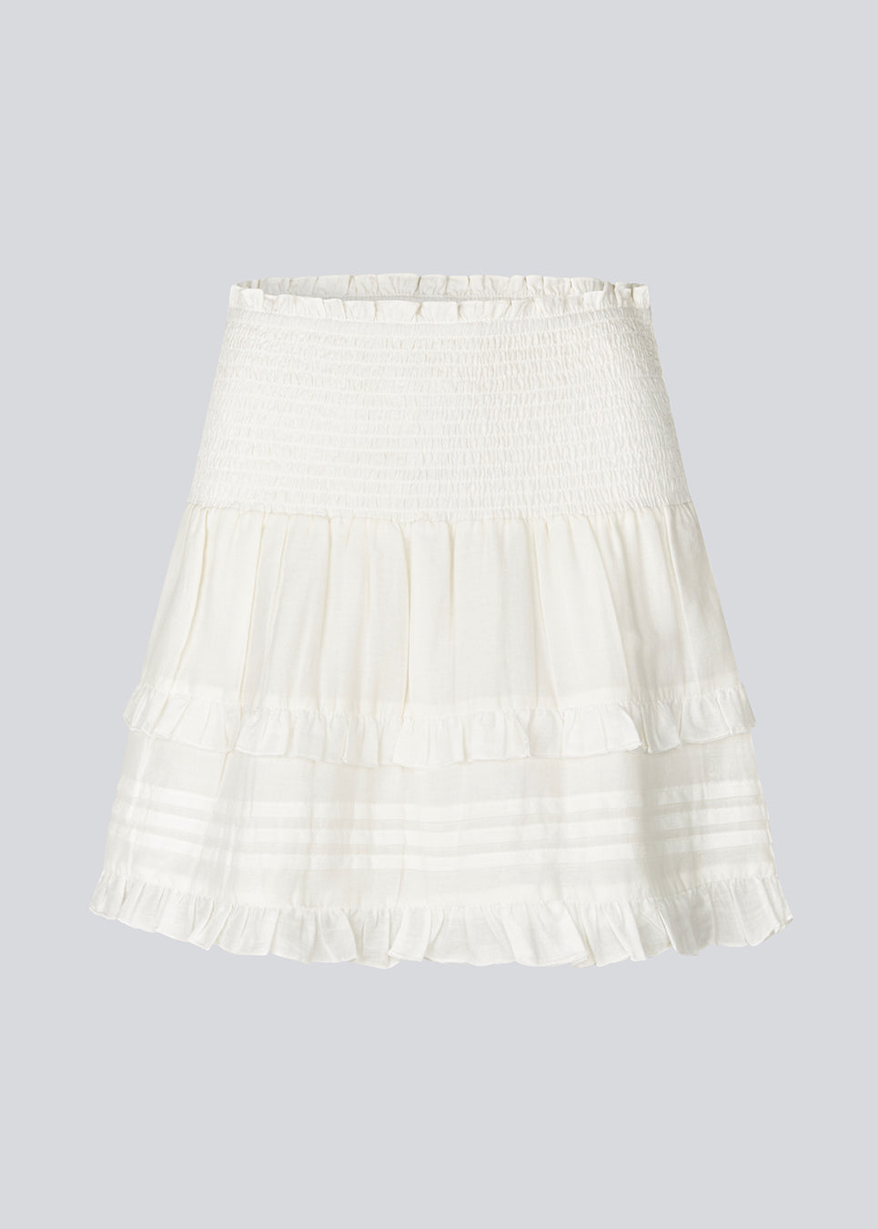 Short white skirt in 100% organic cotton. NillaMD short skirt has a loose skirt with pleats and frill details, and an elastic waist with a smock.