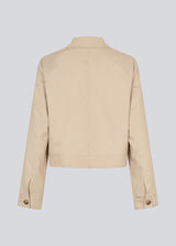 Short beige jacket with a shirt collar and wide sleeves. NormaMD jacket hasa button closure in front and two front pockets.