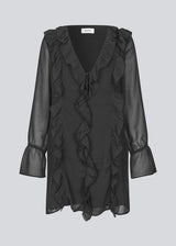 Short black dress with frill details and a loose fit. NorrisMD dress has a v-neck and long, wide sleeves with tiebands.
