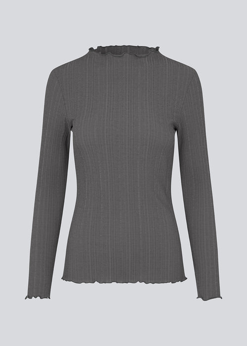 Tight-fitted, long-sleeved t-shirt in dark grey with ruffled trimmings on sleeves, at the neck and bottom. Oasis t-neck fits perfectly as a basic style in the wardrobe. 
