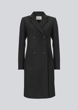 Beautiful, knee-length wool coat in black. Odelia coat is closed at front by 4 buttons and is fitted around the waist, which gives a feminine look. Because of the high content of wool the jacket will be perfect for fall and the mild winters.