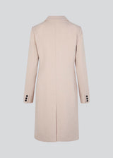 Beautiful, knee-length wool coat. Odelia coat, in season color Summer Sand, is closed at front by 4 buttons and is fitted around the waist, which gives a feminine look. Because of the high content of wool the jacket will be perfect for fall and the mild winters.