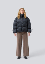 Black puffer jacket with a high neck in 100% recycled polyester. Odinmd jacket has a zipper closure and an adjustable strap at the sleeve. The model is 175 cm and wears a size s/36.