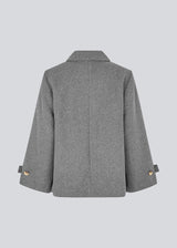 Classic short jacket in a wool mix. Ofiamd jacket has a relaxed fit, hidden button closure and collar. The model is 175 cm and wears a size s/36.