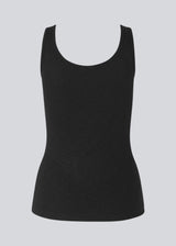 Olla top is a simple black tank top in a soft rib-material. The top has a tight and figure-hugging silhouette which has a soft feel under a knitted sweater or shirt.