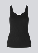 Olla top is a simple black tank top in a soft rib-material. The top has a tight and figure-hugging silhouette which has a soft feel under a knitted sweater or shirt.