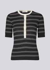 Short-sleeved polo in shimmery knit in the color Black Stripe. Pacifico SS polo has a tight fit and a placket with 5 buttons. The model is 175 cm and wears a size s/36.