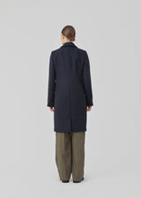 Beautiful, long wool coat in navy. Pamela coat is closed by 3 big buttons at front and is waisted, which gives a feminine look. Because of the high content of wool you will be able to keep warm all through fall and the mild winters.