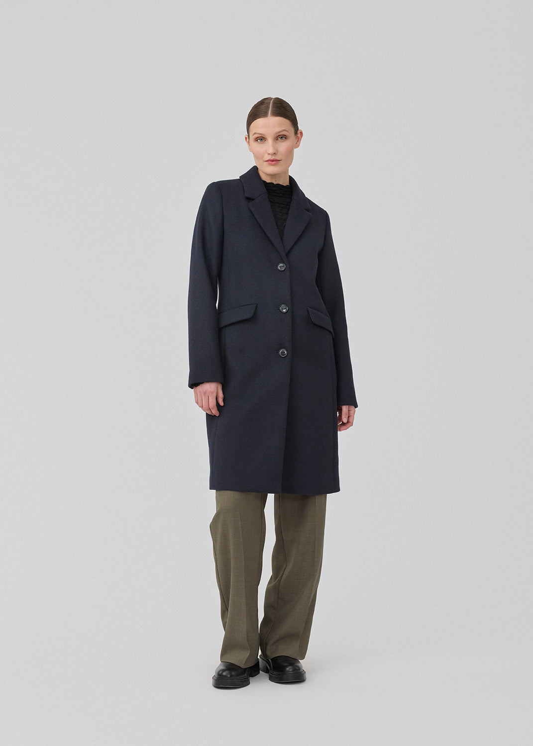 Beautiful, long wool coat in navy. Pamela coat is closed by 3 big buttons at front and is waisted, which gives a feminine look. Because of the high content of wool you will be able to keep warm all through fall and the mild winters.