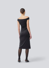 Long off-shoulder dress in elastic recycled material. Parissamd dress is fitted and has ruffle details at the sides. The model is 175 cm and wears a size S/36.