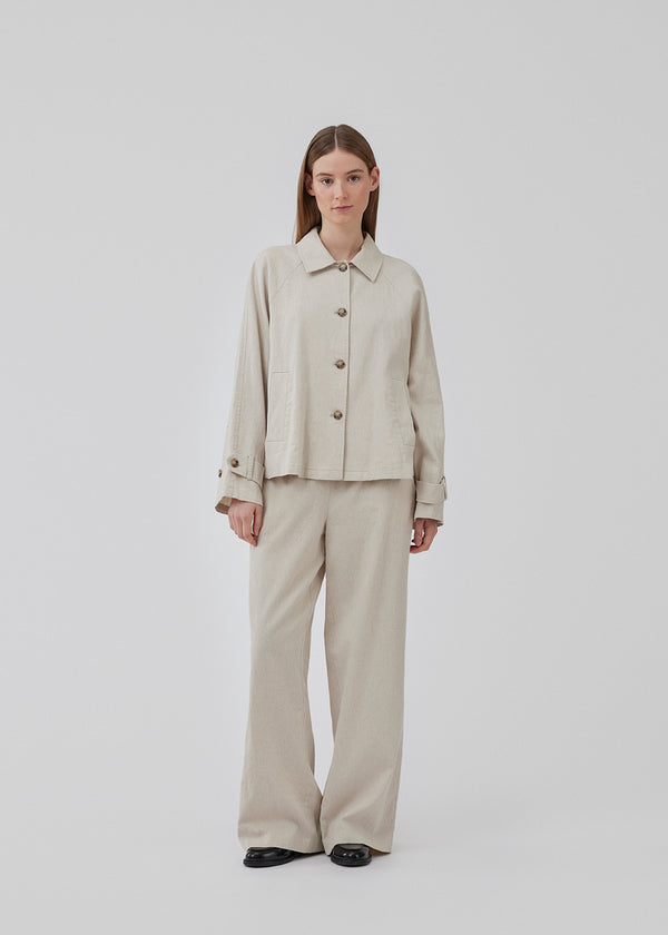 Short trench coat with a casual look in a linen and cotton quality. ParkMD short jacket has a collar, buttons in front, two front pockets, and a strap with button at the cuff. The model is 175 cm and wears a size S/36.