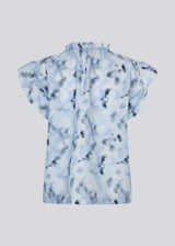 Sleeveless top with ruffled details. Phillipsmd print top has a v-neck with a button closure and ruffles at the neck and sleeves.