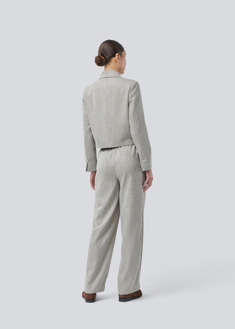 Short jacket with a shirt collar and front button closure. Popemd jacket has long sleeves with slits and a chest pocket. The model is 175 cm and wears a size S/36.
