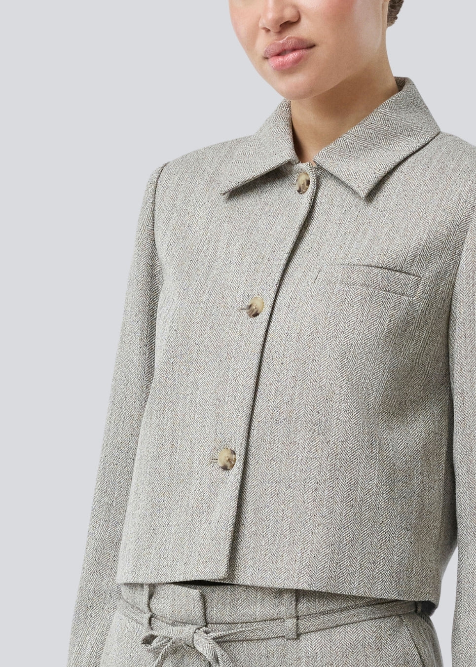 Short jacket with a shirt collar and front button closure. Popemd jacket has long sleeves with slits and a chest pocket. The model is 175 cm and wears a size S/36.
