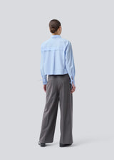 Grey long suit trousers with wide legs. Primrosemd pants have pleats and side pockets. The model is 175 cm and wears a size s/36.