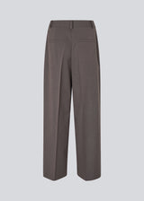 Grey long suit trousers with wide legs. Primrosemd pants have pleats and side pockets. The model is 175 cm and wears a size s/36.