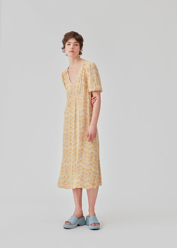 Feminine dress in floral printed EcoVero viscose. RavenMD long print dress is full length with flattering smock details on shoulder and waist. The model is 173 cm and wears a size S/36