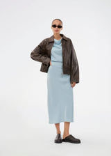 Sleeveless maxi dress in blue with pleats in the side. TailorMD dress is made in satin and has a high neck, invisible zipper in the back and a slit in the side seam. The model is 175 cm and wears a size s/36.