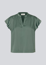 Sleeveless top with frilly details. TailorMD SS top has a loose fit and a V-neck. The model is 177 cm and wears a size S/36.