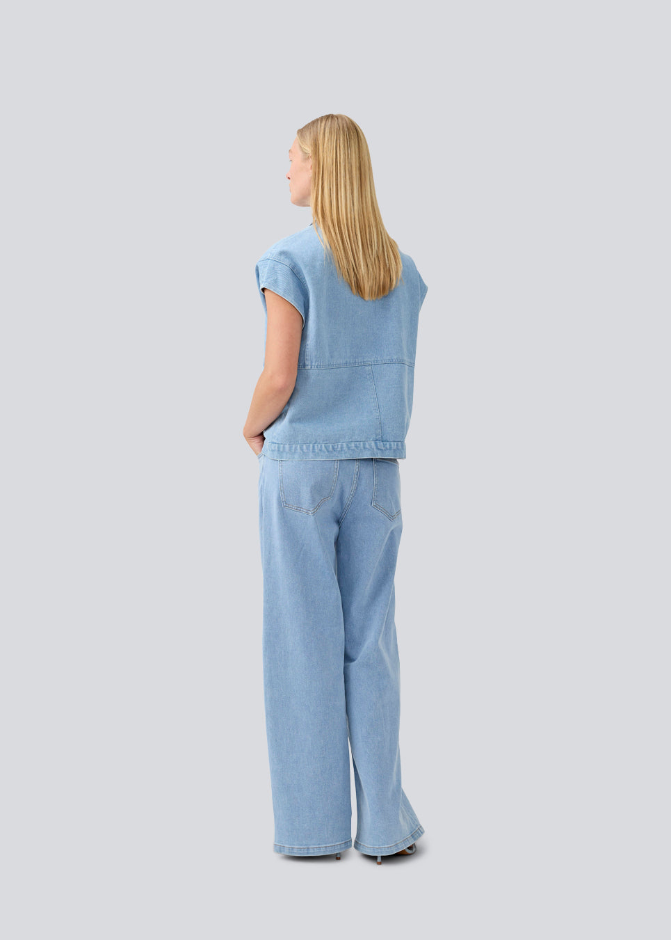 Vest with a loose fit and dropped shoulders in denim. TenorMD vest has two pockets, shirt collar and a button closure in front.