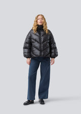 Puffer jacket with a high neck in 100% recycled polyester. Tetrismd jacket has a zipper closure and an adjustable strap at the sleeve.