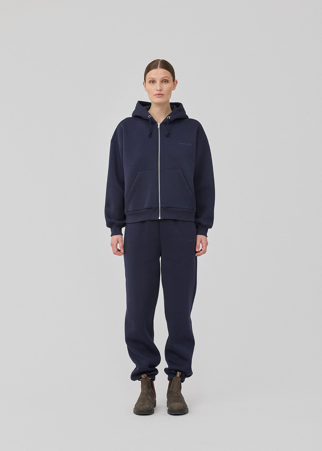 <p>Sweatshirt in navy blue with a zipper and logo in a cotton mixture. TiaMD Zip has pockets, ribbing at the sleeves and bottom, and a hood with strings.</p> <p><a href="https://modstrom.com/products/tiamd-pants-navy-sky" title="tiamd-pants-navy-sky">Style with matching pants.</a></p>