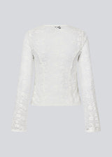 Fitted top in white stretchy lace with flared sleeves. TildeMD lace top has a deep V-neckline and two tiebands in the front.