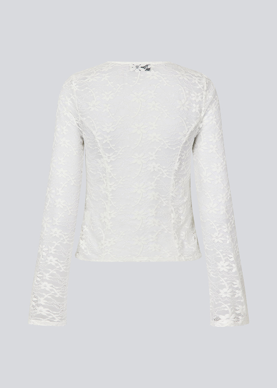 Fitted top in white stretchy lace with flared sleeves. TildeMD lace top has a deep V-neckline and two tiebands in the front.