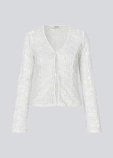 Fitted top in white stretchy lace with flared sleeves. TildeMD lace top has a deep V-neckline and two tiebands in the front.