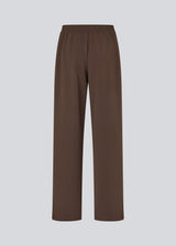 Loose brown trousers with wide legs and a relaxed fit. Featuring an elastic waistband with drawstring for a comfortable, adjustable waist. White side stripes add a sporty and modern touch to the otherwise classic design. Perfect for casual everyday wear or more elevated styling – easy to pair with everything from t-shirts to dressy tops.