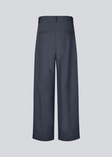 Suit pants in Twill with wide legs and pleats at the top in dark blue. ToreMD pants have a medium-high waist, zipper, side pockets and paspoil pocket in the back.