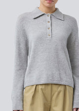 Knitted polo in grey with long, wide sleeves. Treemd polo has a placket closure and 4 buttons. The model is 175 cm and wears a size S/36.