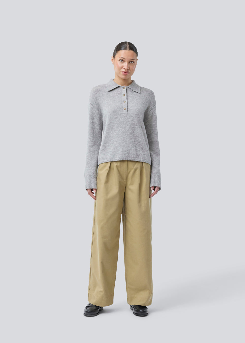 Knitted polo in grey with long, wide sleeves. Treemd polo has a placket closure and 4 buttons. The model is 175 cm and wears a size S/36.