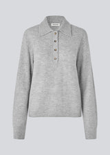 Knitted polo in grey with long, wide sleeves. Treemd polo has a placket closure and 4 buttons. The model is 175 cm and wears a size S/36.